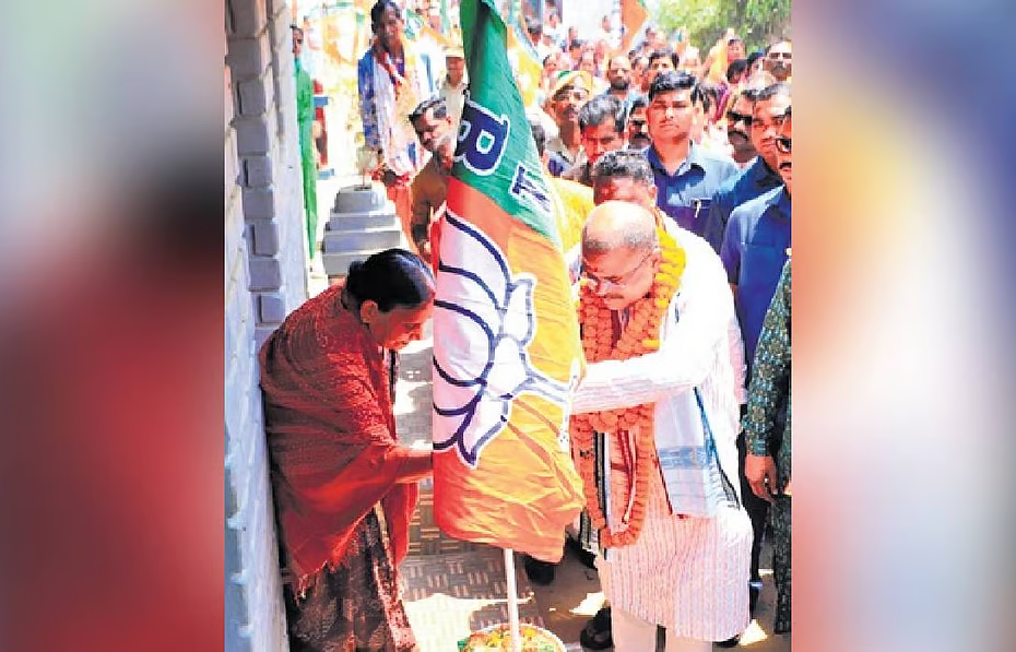 Union Education Minister Dharmendra Pradhan installing BJP flag at the house of a party worker on Sunday
